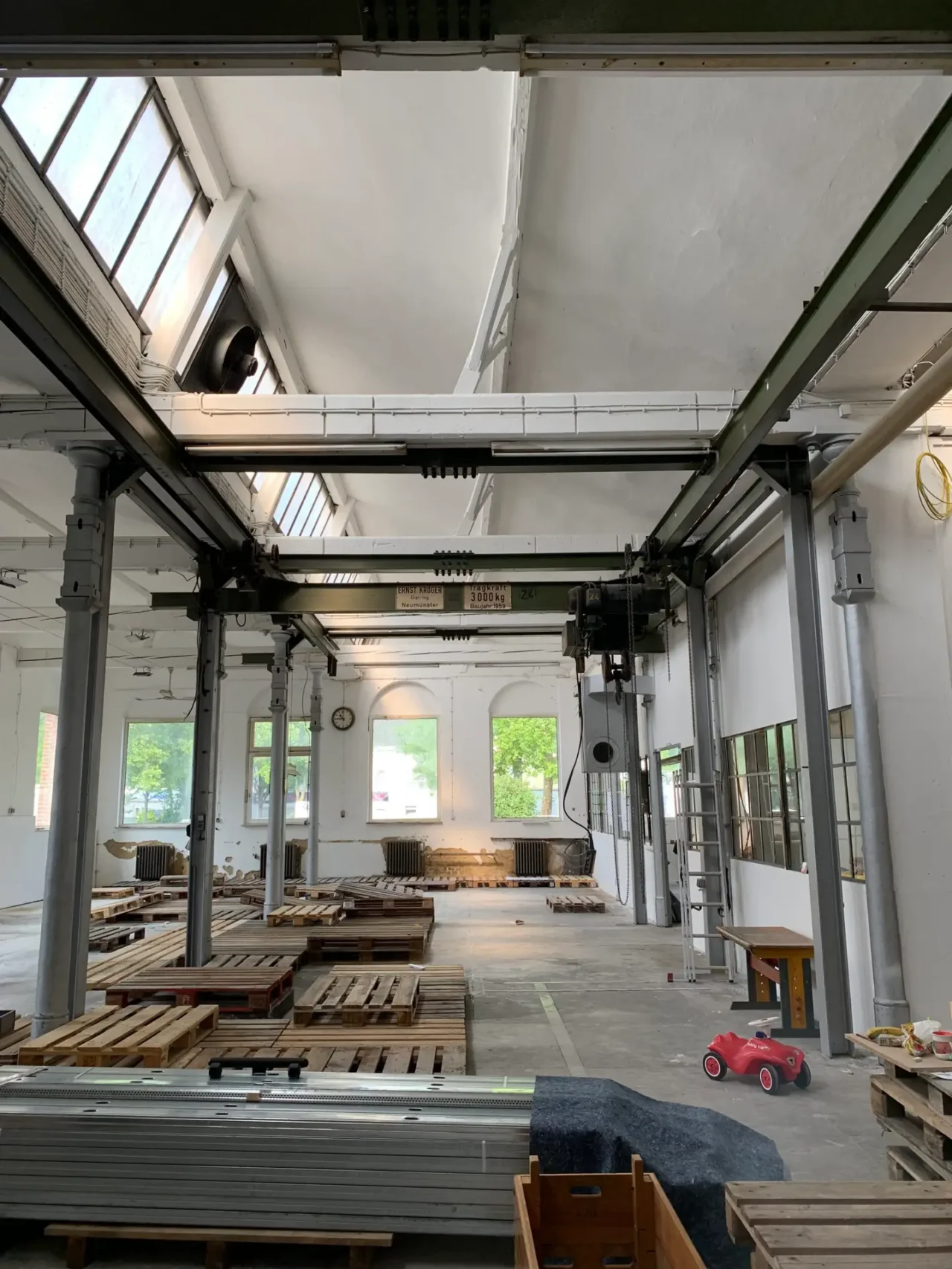 Blick in die frisch weiss gestrichene Halle mit Paletten, auf denen später die Aufbauten stehen sollen.