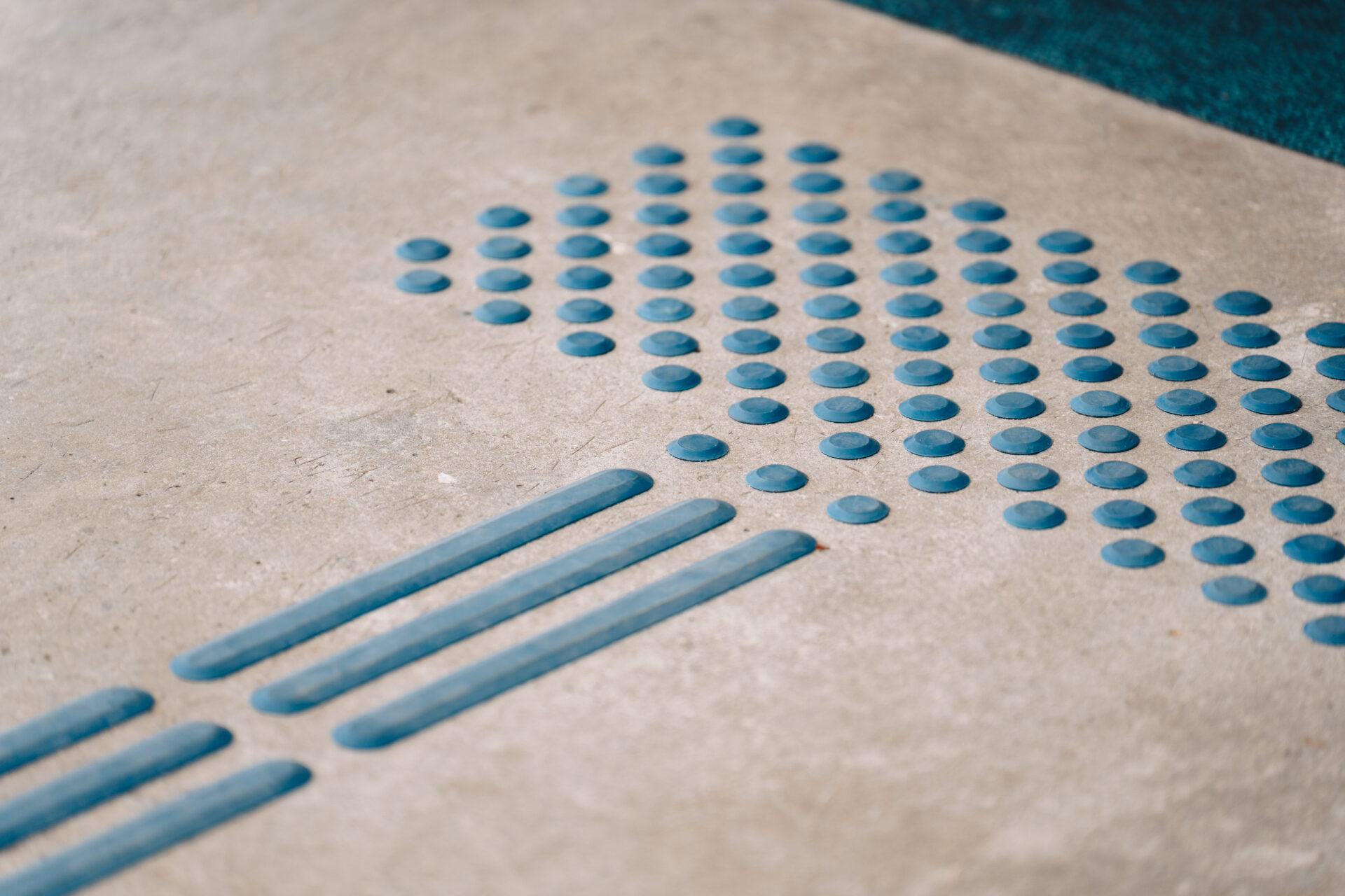 taktiles Leitsystem in blau auf Betonboden